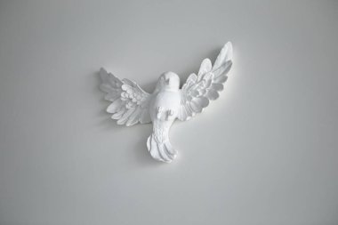 Kil seramik taş figürler, oturma odasındaki beyaz duvardaki manken kuşun heykeli. Minimalizm dekorasyon tasarım tarzı. Boş alanı kopyalayan resim.