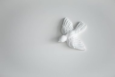Kil seramik taş figürler, oturma odasındaki beyaz duvardaki manken kuşun heykeli. Minimalizm dekorasyon tasarım tarzı. Boş alanı kopyalayan resim.
