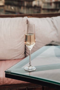 Restorandaki yemek masasının üzerinde duran soğuk şampanyalı kristal cam dikey yakın çekim, içinde kabarcıklar var. Fotokopi alanı ve bokeh arkaplanı olan alkol içeceği.