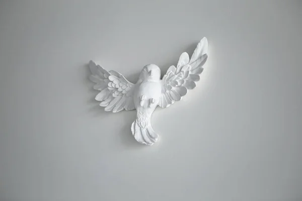 Kil seramik taş figürler, oturma odasındaki beyaz duvardaki manken kuşun heykeli. Minimalizm dekorasyon tasarım tarzı. Boş alanı kopyalayan resim.