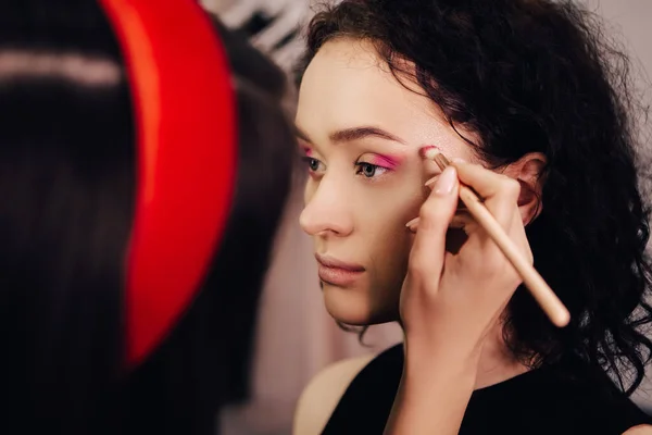 Renkli Pembe Pudra Süren Bir Kadına Maquillage Yapan Bir Makyöz — Stok fotoğraf