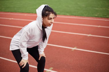 Koşu bandı, başlangıç için. Sportif yorgun kadın maraton triatlonu için hazırlanıyor. Stadyumda kadın yorgun, yorgun, secde koşusu antrenmanı yapıyor. Resim kopyalama alanı