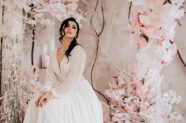 Evli kadın nişanı kutluyor. Stüdyoda beyaz çiçeklerden yapılmış pembe düğün fotoğrafı. Resim yapmak için bir yer. Üreme romantik kadın kapalı, kopyalama alanı.