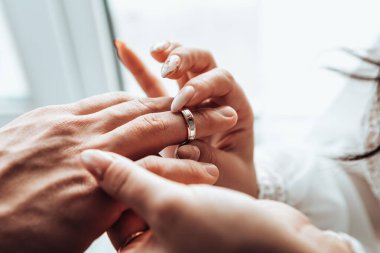 Gelin ve damat parmağına alyans takıyor. Karı koca pencere kenarındaki iki sevgili düğün törenini kutluyorlar. Çiftleşme romantik yeni evliler kapalı alanda, kopyalama alanı.