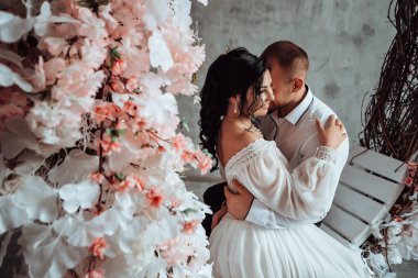 Karı koca fotoğraf stüdyosunda kucaklaşıyorlar. Evlenen gelin ve damat nişanlarını kutluyorlar. Romantik aşıklar, yeni evli çiftler, kopyalama alanı..