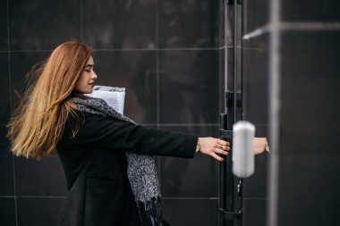 Gülümseyen mutlu kadının evrak sözleşmesi, aceleyle koşmak için işe geç kalmaktır. İş arayan bir kadın. Küçük bir işletme sahibi, ortak alan. Serbest çalışan ofis çalışanı kapıyı aç, zaman yönetimi