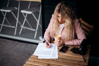 1 Ekim, Uluslararası Kahve Günü! Çekici sarı saçlı bayan ahşap masa kafeteryasında oturuyor işten sonra iş kadını sipariş bekliyor sıcak içecek, kahve molası, fotokopi odası.