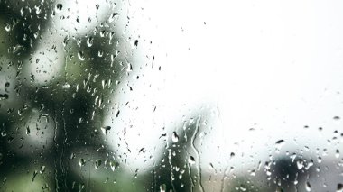 Close up macro shot falling rain water drops bubbles on wet window glass flat house appartment nature blur bokeh background, condensation on the surface, droplet plash steam drip, copy space 