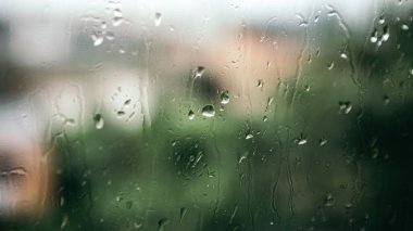 Close up macro shot falling rain water drops bubbles on wet window glass flat house appartment nature blur bokeh background, condensation on the surface, droplet plash steam drip, copy space 