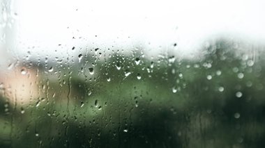 Close up macro shot falling rain water drops bubbles on wet window glass flat house appartment nature blur bokeh background, condensation on the surface, droplet plash steam drip, copy space 