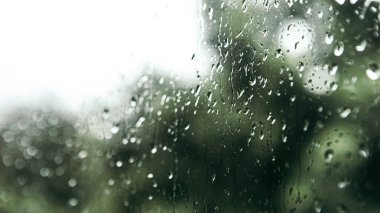 Close up macro shot falling rain water drops bubbles on wet window glass flat house appartment nature blur bokeh background, condensation on the surface, droplet plash steam drip, copy space 