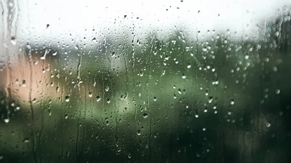 Close up macro shot falling rain water drops bubbles on wet window glass flat house appartment nature blur bokeh background, condensation on the surface, droplet plash steam drip, copy space 