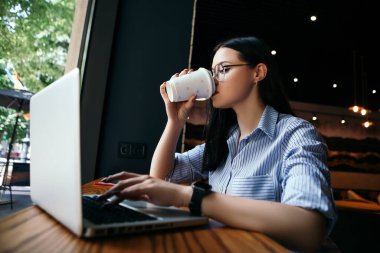İş kadını serbest çalışan, kafede oturan, sıcak meşrubat içen, öğle yemeği arası veren, dizüstü bilgisayarda mesaj yazan akıllı saat elinin şık gözlük taktığı bir fotokopi odası. Uluslararası Kahve Günü! 