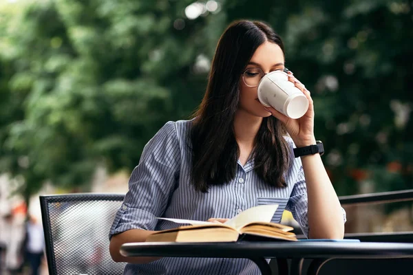 Business woman sitting outside terrace porch cafe drink hot beverage coffee break have lunch reading book smart watch hand wear stylish glasses copyspace. Rush hour, International Coffee Day