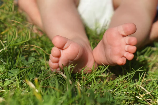 Baby voeten op gras — Stockfoto