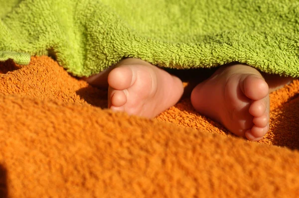Baby voeten onder deken — Stockfoto