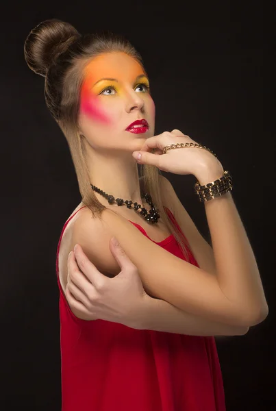 Ragazza in un abito rosso con brillante trucco creativo — Foto Stock