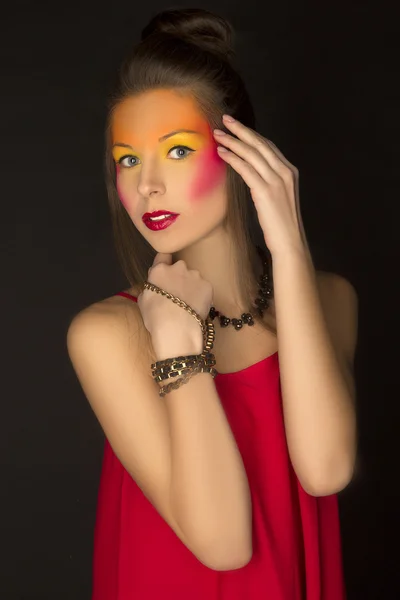 Ragazza in un abito rosso con brillante trucco creativo — Foto Stock