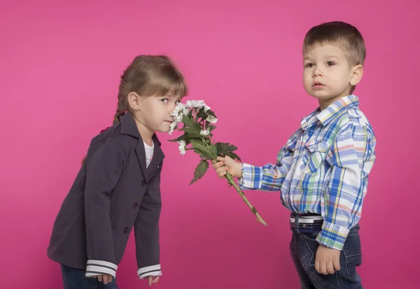 Kleine jongen geeft een meisje bloemen — Stockfoto