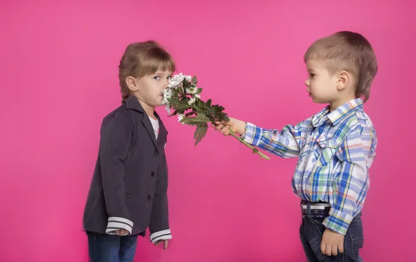 Petit garçon donne une fille fleurs — Photo