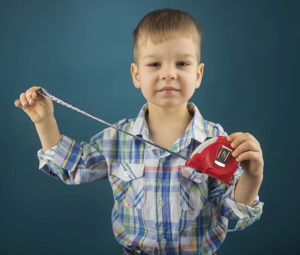 Niño pequeño con una cinta métrica en la mano azul — Foto de Stock