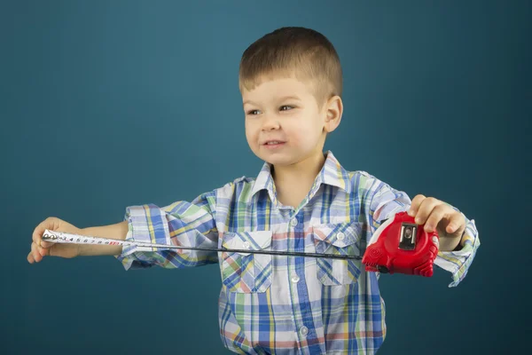 Niño pequeño con una cinta métrica en la mano azul —  Fotos de Stock