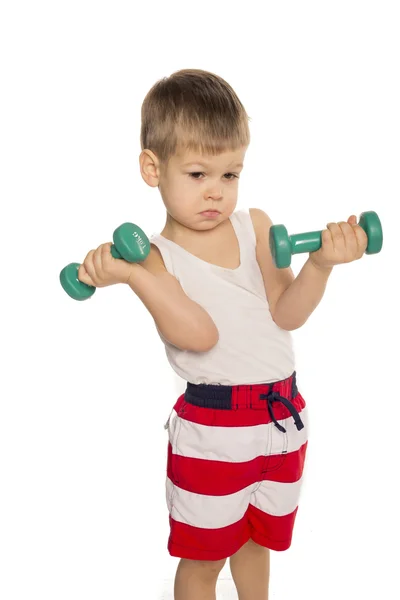 Little boy picks up a dumbbell — Stock Photo, Image