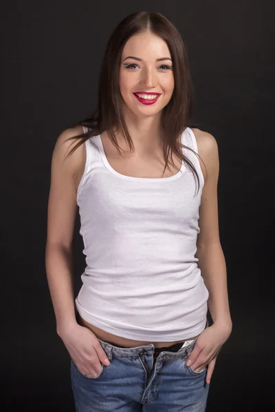 Krásná usměvavá dívka v bílém tričku a džínách Royalty Free Stock Obrázky