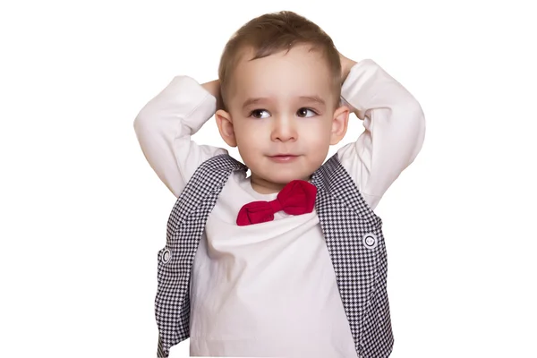 Niño pequeño con un traje a cuadros y pajarita sosteniendo su cabeza — Foto de Stock