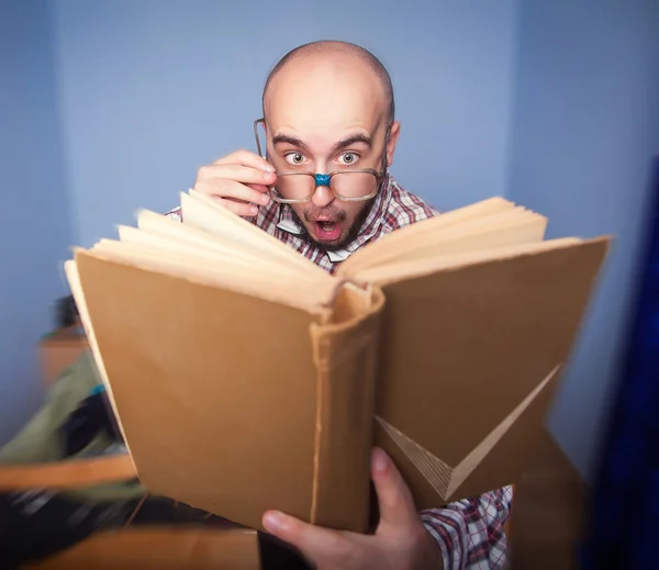 Surprised nerd reading a book — Stock Photo, Image