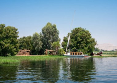 Luxor, Mısır - 27.07.2025. Nil Nehri manzaralı kıyı şeridi boyunca oteller ve binalar ve açık mavi bir gökyüzü.