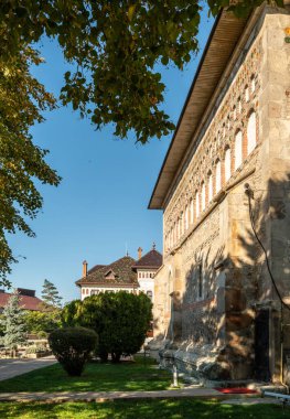 Piatra Neamt, Romanya 16.10.2025. Romanya 'nın Piatra Neamt kentindeki tarihi Prenslik Kilisesi' nin dikey çekimleri, dekoratif kemerlerle süslü taş ve tuğla yan cepheyi de içeriyor.