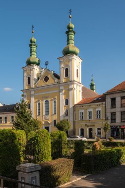Targu Mures, Romanya - Ekim 17.2025. Aziz Vaftizci Yahya 'nın Roma Katolik Kilisesi' nin beyaz, tarihi kulesi Targu Mures 'te trafik ve ağaçlarla çevrili açık mavi gökyüzüne karşı dimdik ayakta duruyor.