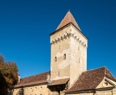 Medya, Romanya - Ekim 20.2025. Tarihi Trompetçiler Kulesi 'nin manzarası ve ortaçağ medyasının açık mavi gökyüzünün altındaki güçlendirilmiş kilise duvarları.