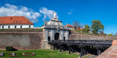 Alba Iulia, Romanya - Ekim 19.2025. Romanya 'daki Alba Carolina Kalesi' ndeki tarihi ahşap köprünün sonunda heykeli olan süslü bir barok taş kapı duruyor.