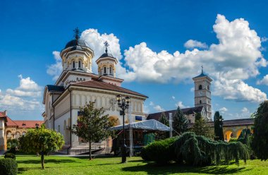 Alba Iulia, Romanya - Ekim 19.2025. İç avlunun sakin manzarası kemerli galeriler, manikürlü yeşillik ve taç giyme törenindeki geleneksel mimari.