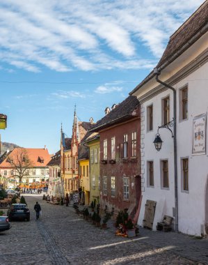 Sighisoara, Romanya - 21.10.2025. 13. yüzyıldan kalma Dominik Manastırı Kilisesi 'nin yan manzarası, UNESCO Sighisoara Kalesi içindeki sarp kırmızı kiremitli ve kemerli pencereli Gotik bir anıt.