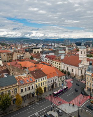 Cluj-Napoca, Romanya - Ekim 18.2025 Romanya 'nın Cluj-Napoca kentinin tarihi merkezi, bulutlu bir gökyüzü altında geleneksel kırmızı başlıklı çatılar, şehir sokakları ve St. Michael Kilisesi' ni gösteriyor.