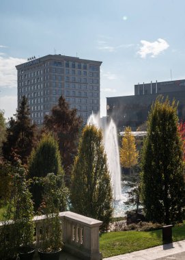 Iasi, Romanya - 23 Ekim 2025. Romanya 'da güneşli bir günde modern binalar ve renkli sonbahar ağaçlarıyla dolu Palas Iasi bahçesi