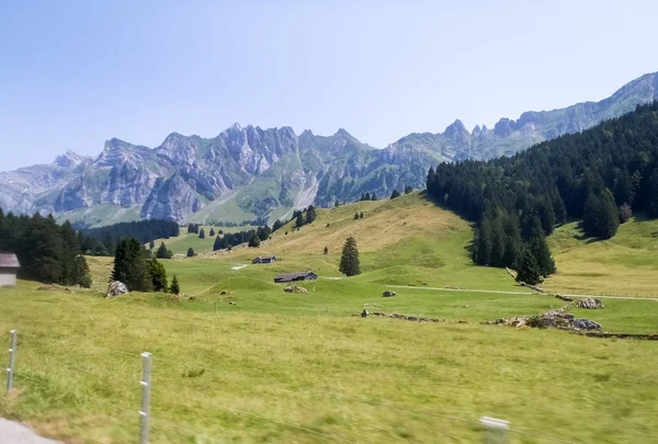 Švýcarská krajina, hory a zelené louky — Stock fotografie