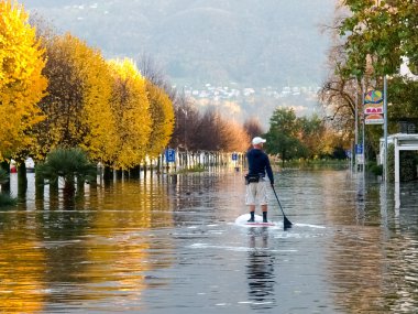 Bilinmeyen insanlar su dolu yolda sörf