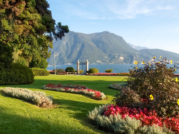 Lugano, Switzerland: Park of the City. Picture from the botanical park by the lake and surrounding mountains with flowers