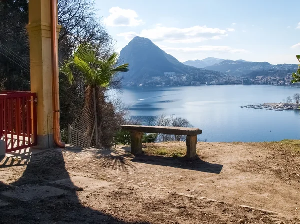 Marble bench overlooking the gulf of Lugano and Mount San Salvat — Stock Photo, Image