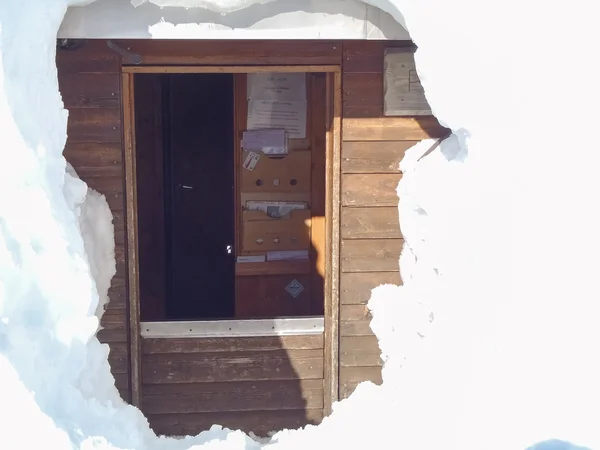 Verschneite Berghütte in Holz — Stockfoto