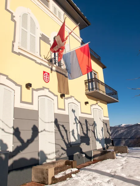 Vista de la fachada de la luz solar con banderas — Foto de Stock