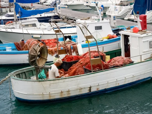 Rybář systém sítě na malé lodi kotvící v přístavu — Stock fotografie
