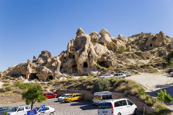 CAPPADOCIA, TURCHIA - 25 GIUGNO 2014: Foto di parcheggio auto sullo sfondo di rocce con grotte artificiali nel Parco Nazionale di Goreme — Foto Stock