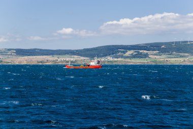 DARDANELLES STRAIT, TURKEY - JUN 29, 2014: Photo of seascape with cargo ship clipart