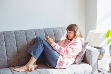 Koltukta cep telefonu kullanan genç bir kadın..