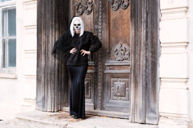 Kafatası makyajlı siyah elbiseli zarif bir kadın..